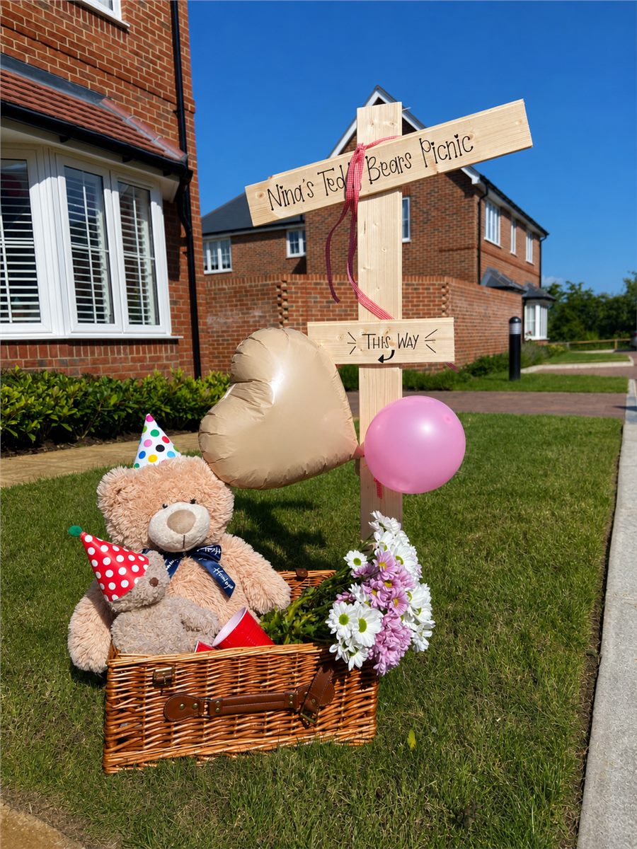 Teddy picnic direction sign with party decorations.
